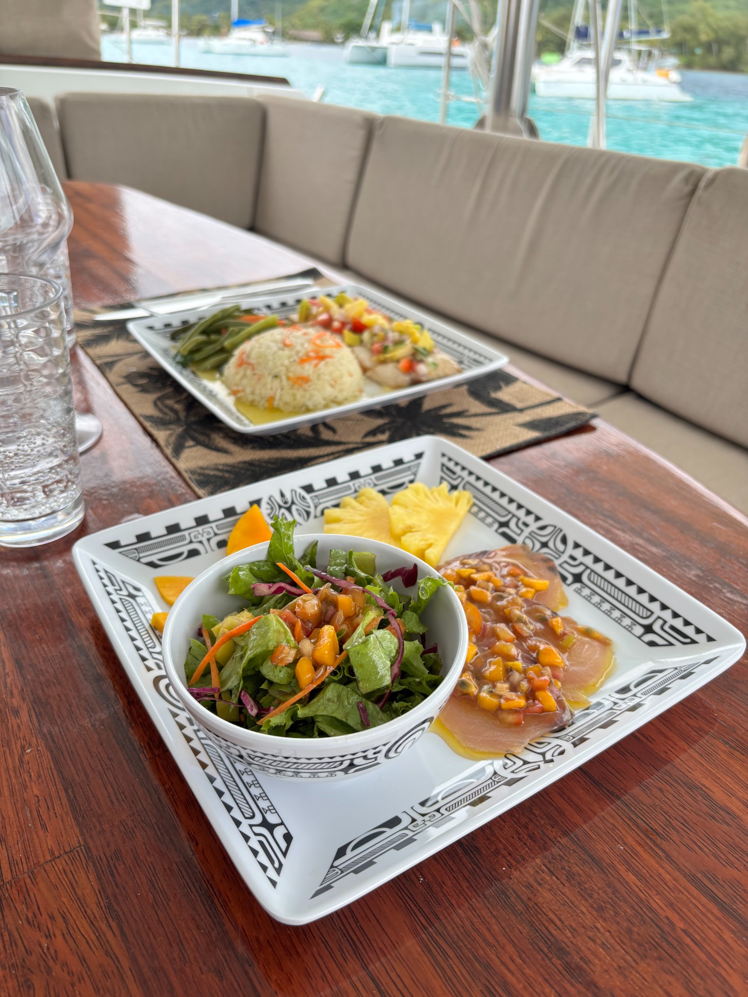Fish carpaccio and tropical fruit served aboard the catamaran
