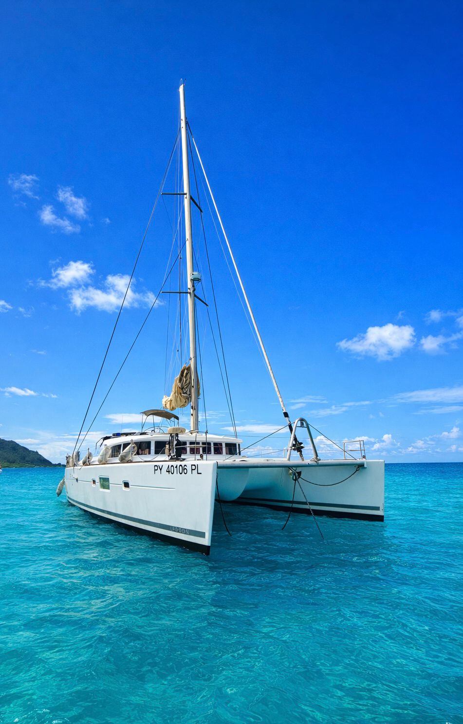 TUATAU V at anchor under a blue sky in Moorea’s lagoon