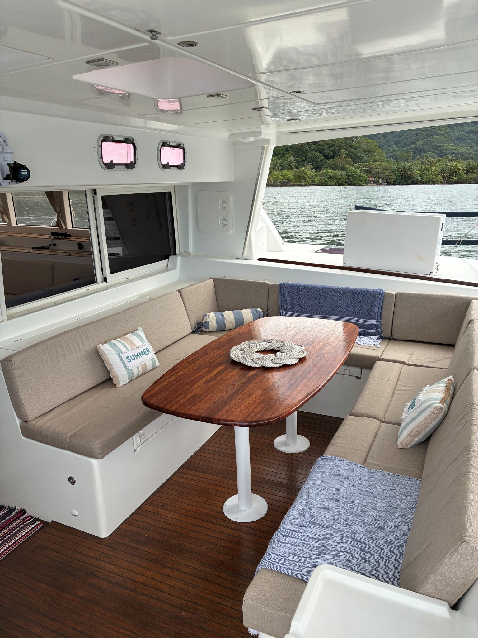 Shaded cockpit dining table and cushioned seating aboard TUATAU V
