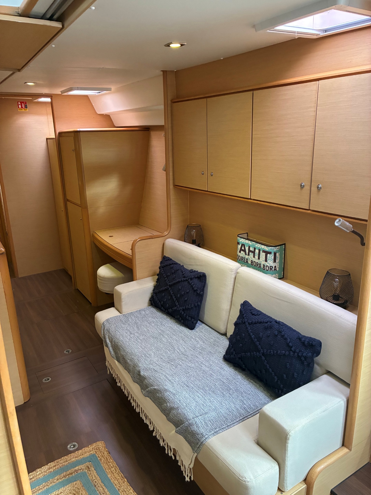 A quiet interior seating area with cushions and wooden cabinetry