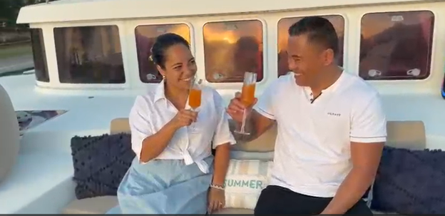 A couple enjoying a toast aboard TUATAU V in the golden afternoon light